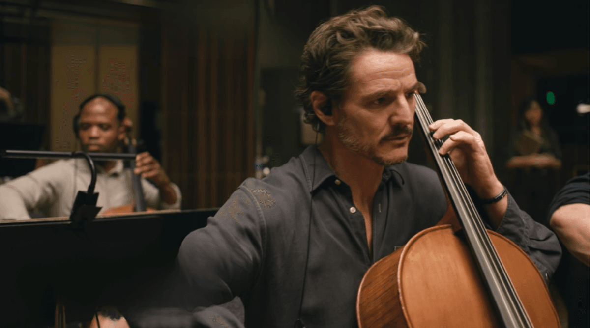 Pedro Pascal focused, playing cello, in a recording studio Behemoth!