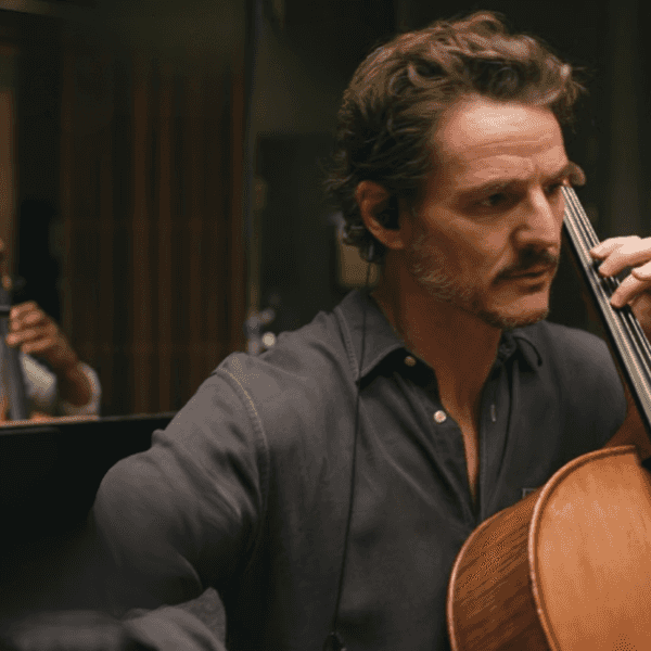 Pedro Pascal focused, playing cello, in a recording studio Behemoth!