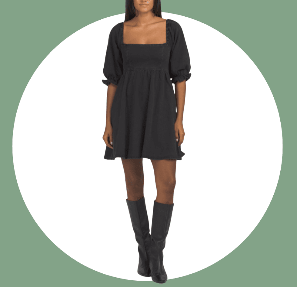 Person in a black square-neck dress with puff sleeves and knee-high boots.