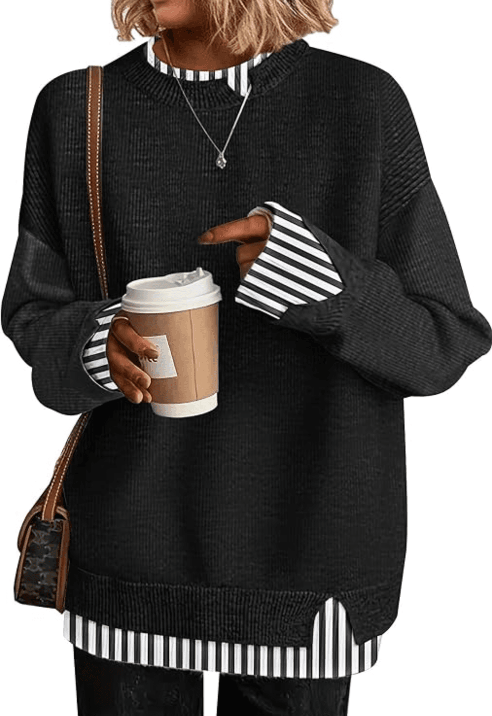 Person in a black sweater holds a coffee cup, wearing a striped shirt underneath.