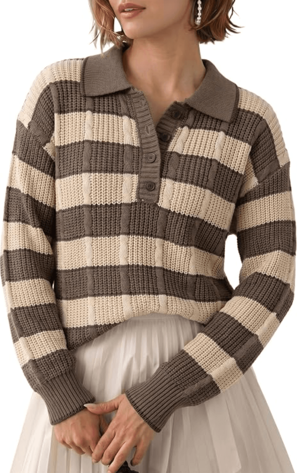 Person in a brown and cream striped knit sweater and pleated skirt.