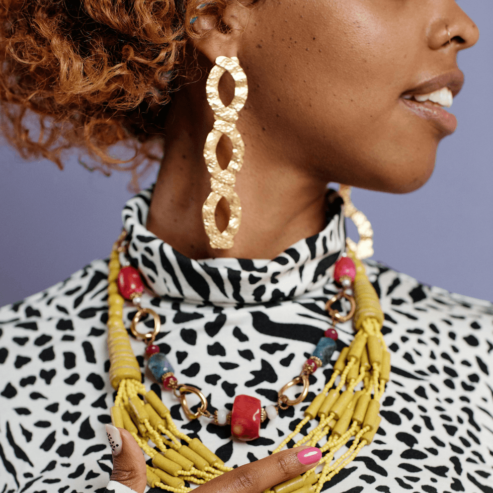 Person in a cheetah print top wearing colorful statement jewelry