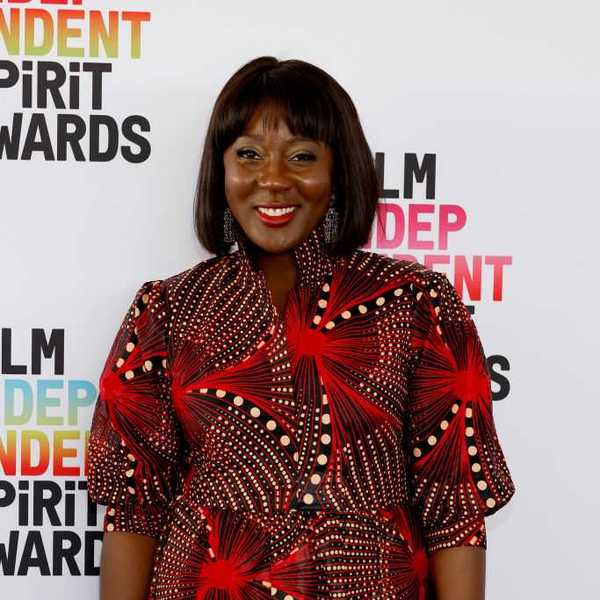 Person in a red patterned dress at the Film Independent Spirit Awards.