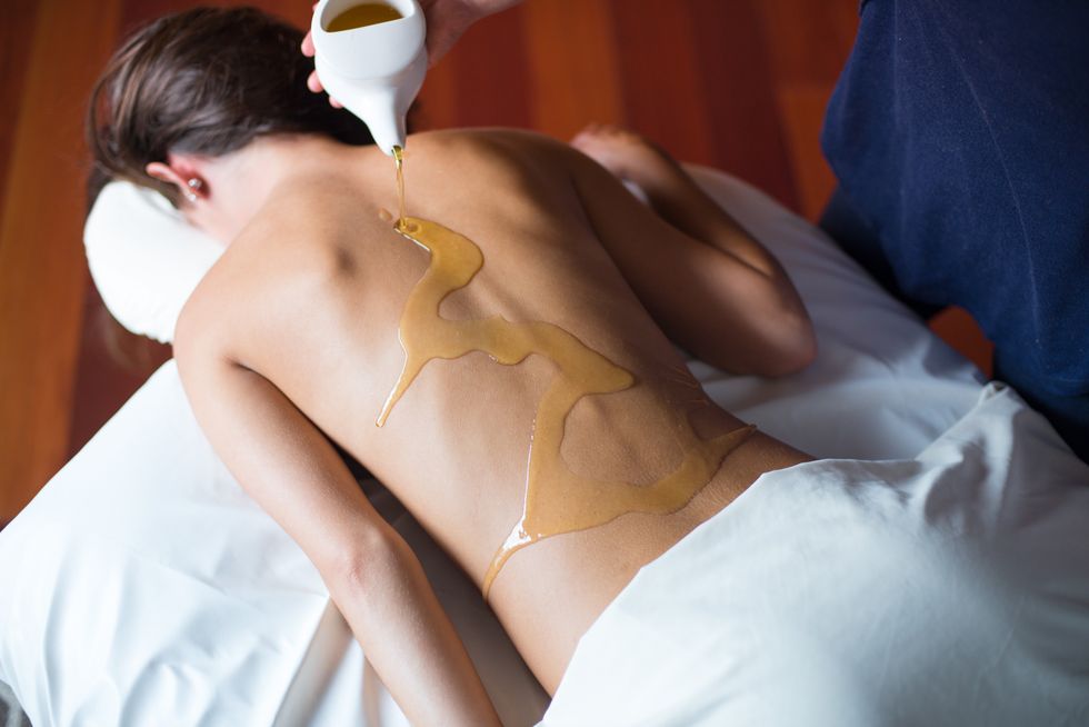 Person receiving a relaxing oil massage on their back in a spa setting.