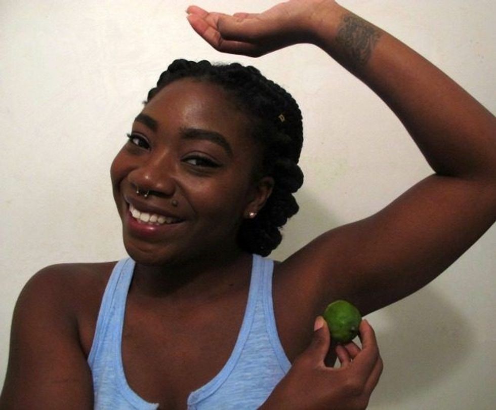 Person smiling and applying a lime to their armpit with a lifted arm.