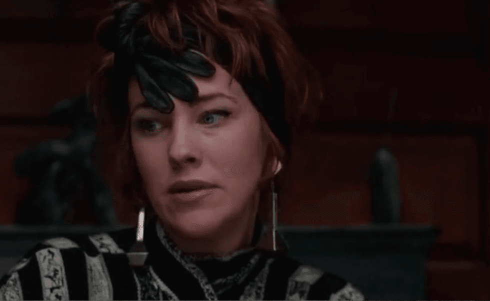 Person with a black feather hat and striped outfit, looking to the side.