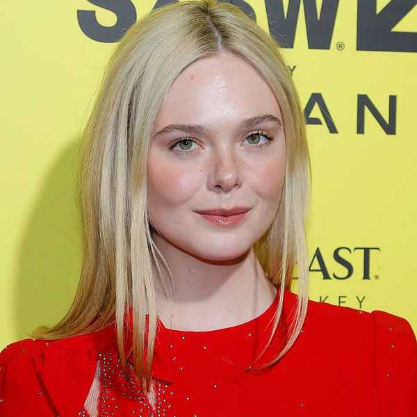 Person with blonde hair in a red outfit, standing against a yellow background.