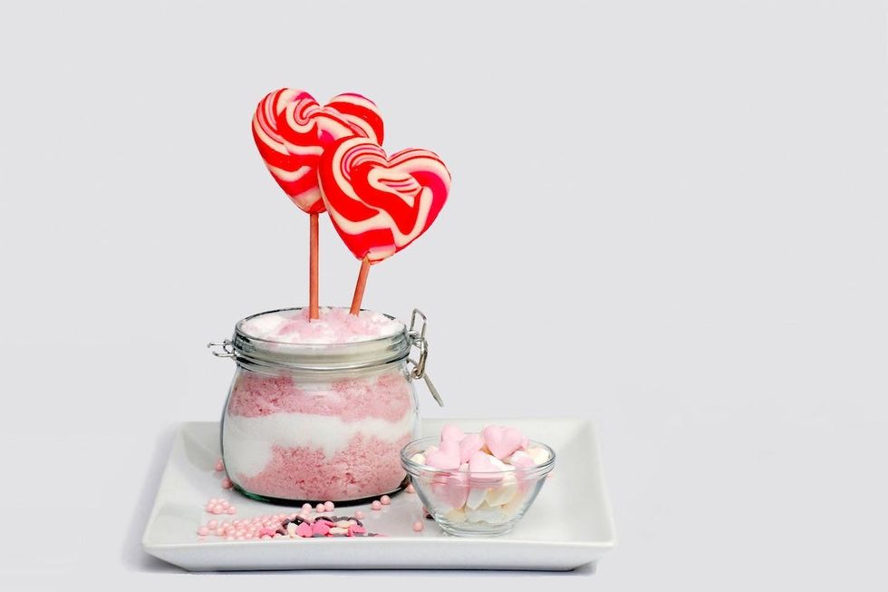 pink and white lollipops sticking out of a sugar scrub