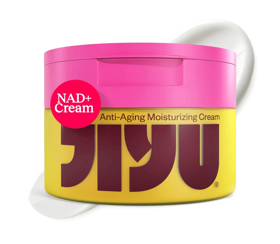 Pink and yellow jar of NAD+ Anti-Aging Moisturizing Cream with product visible behind.