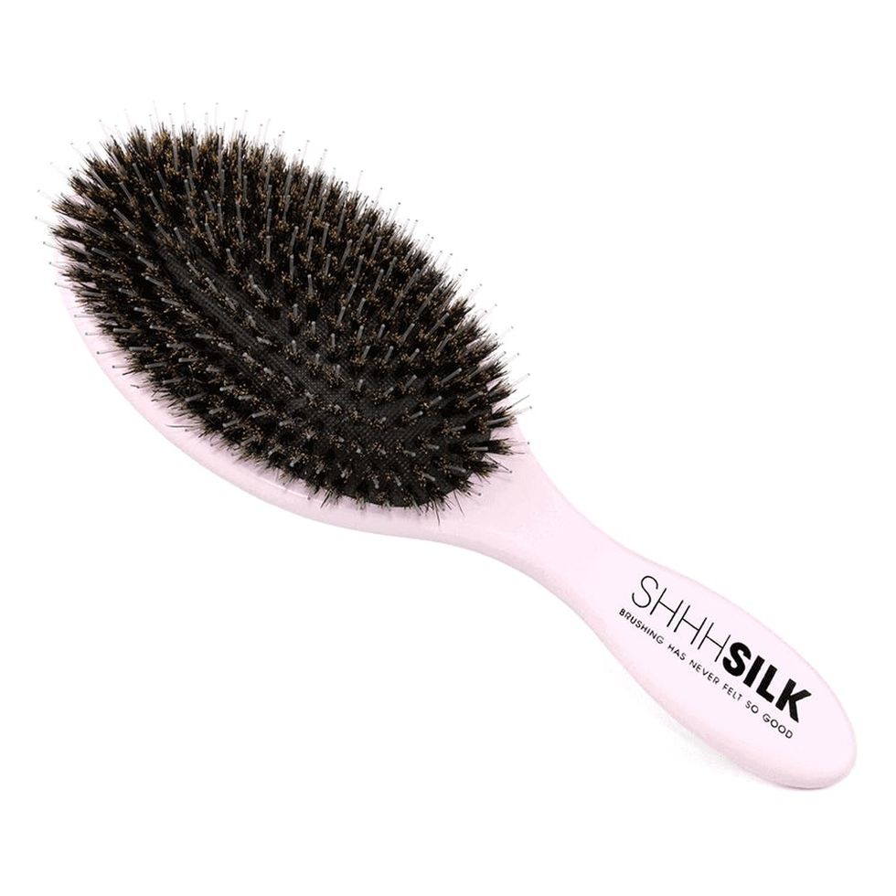 Pink boars bristle brush on a white background.