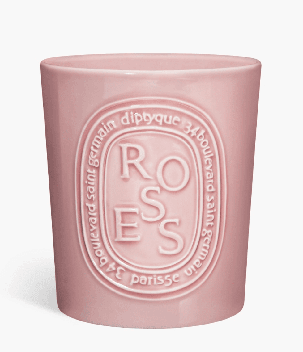 Pink candle holder with embossed "ROSES" and elegant text detailing.