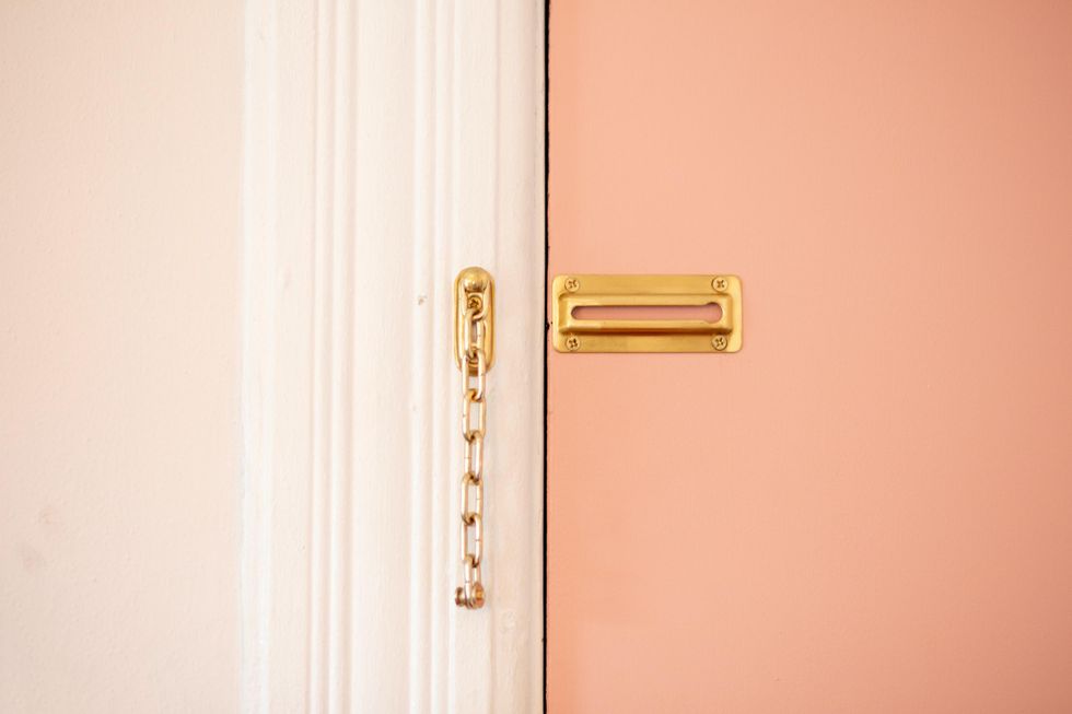 pink door inside white door frame with brass lock traveling alone