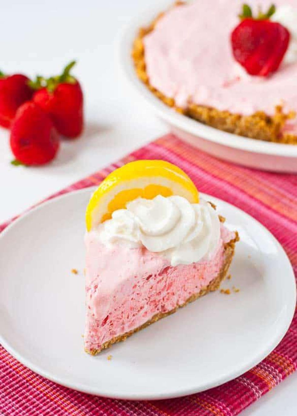 pink frozen strawberry lemonade pie with lemon on top