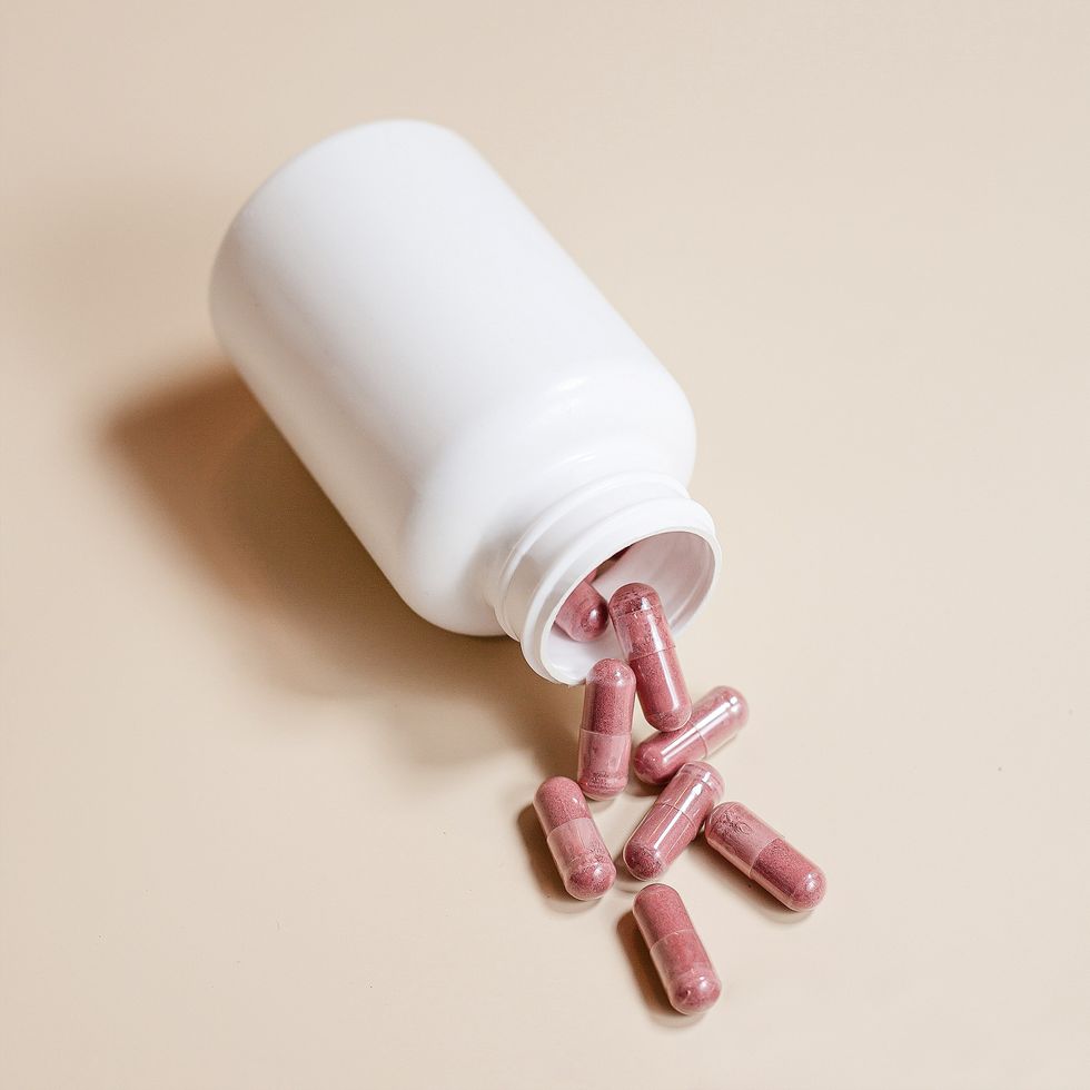 pink pill capsules spilling from bottle