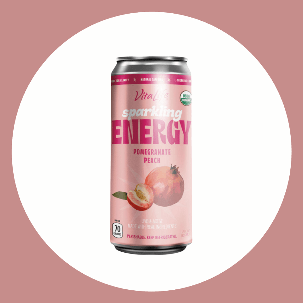 Pink pomegranate-peach sparkling energy drink can on a white and pink background.