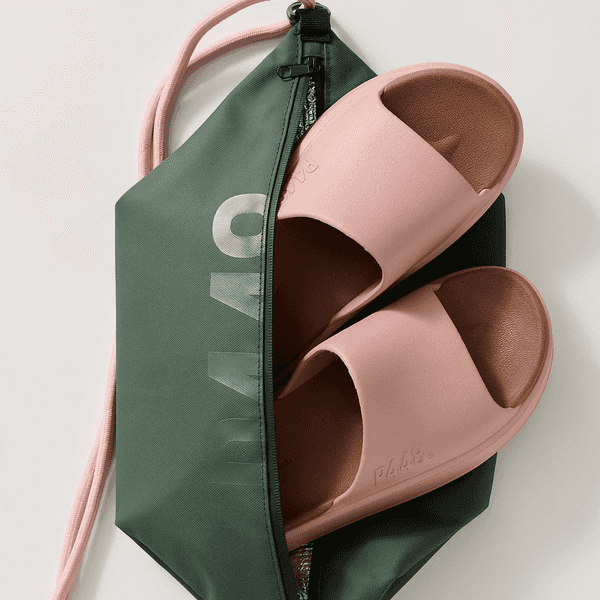 Pink slides partially in a green zippered pouch with a pink strap.
