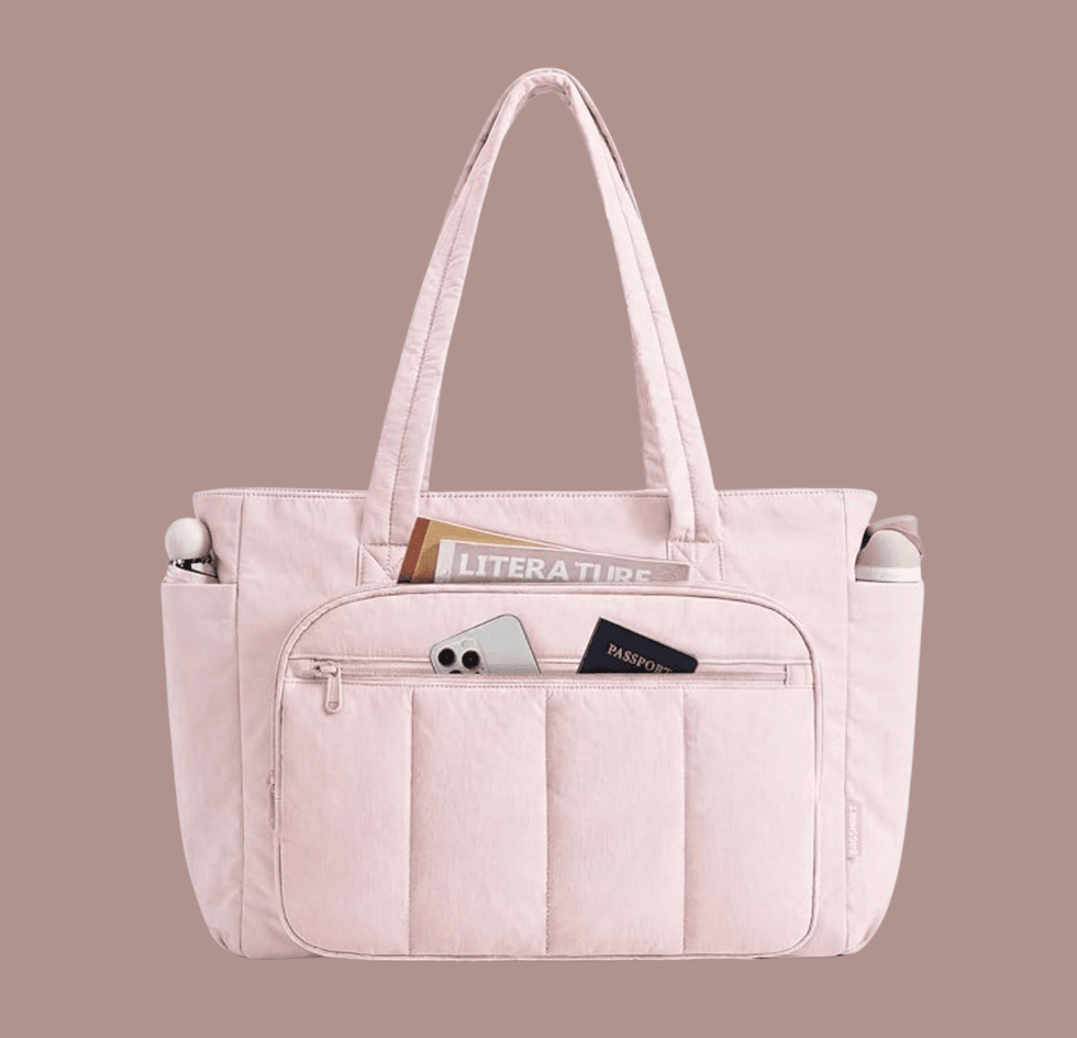Pink tote bag with a phone, passport, and magazine in pockets.