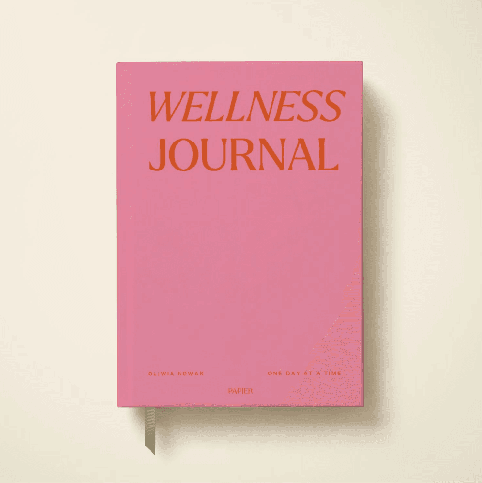 Pink "Wellness Journal" with orange text on a cream background.