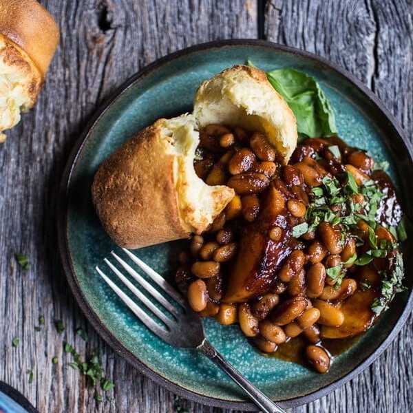 Plate of baked beans and bread on a rustic wooden table.