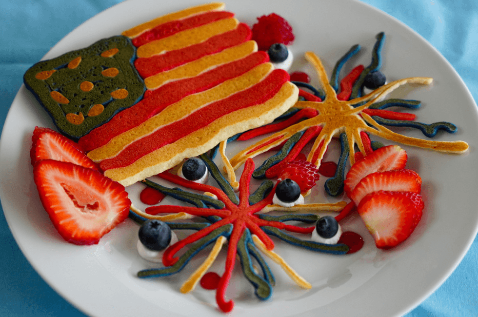 Plate with USA flag pancake, fireworks, strawberries, and blueberries.