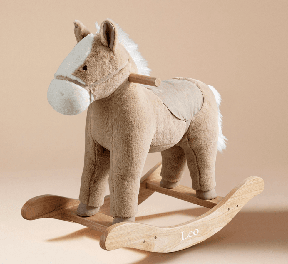 Plush rocking horse with wooden base on a beige background.