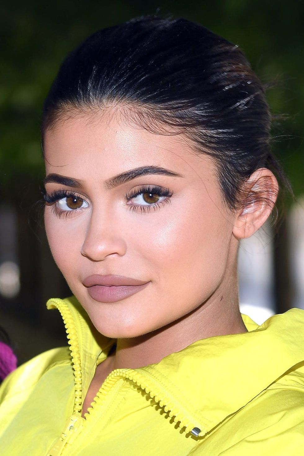 Portrait of Kylie Jenner in a yellow jacket with hair pulled back.