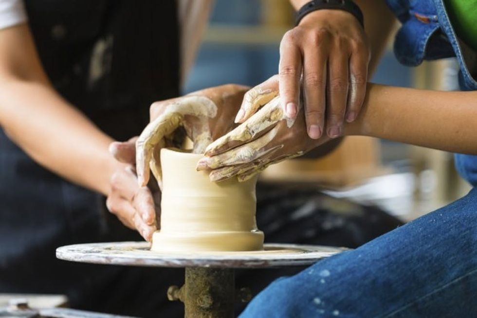 Potter creating clay bowl on turning wheel