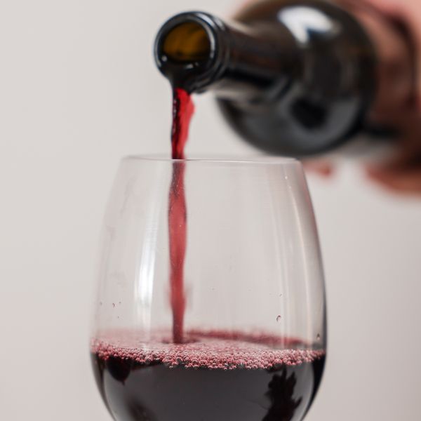 pouring red wine into a glass