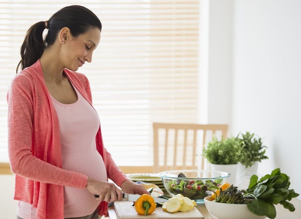 Pregnant woman making salad
