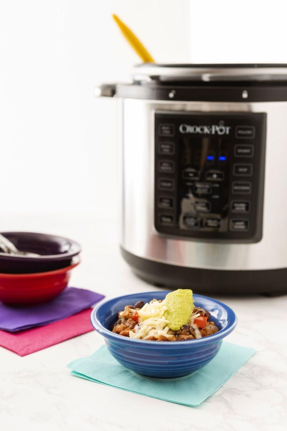 pressure cooked veggie quinoa chili in a blue bowl on a teal napkin