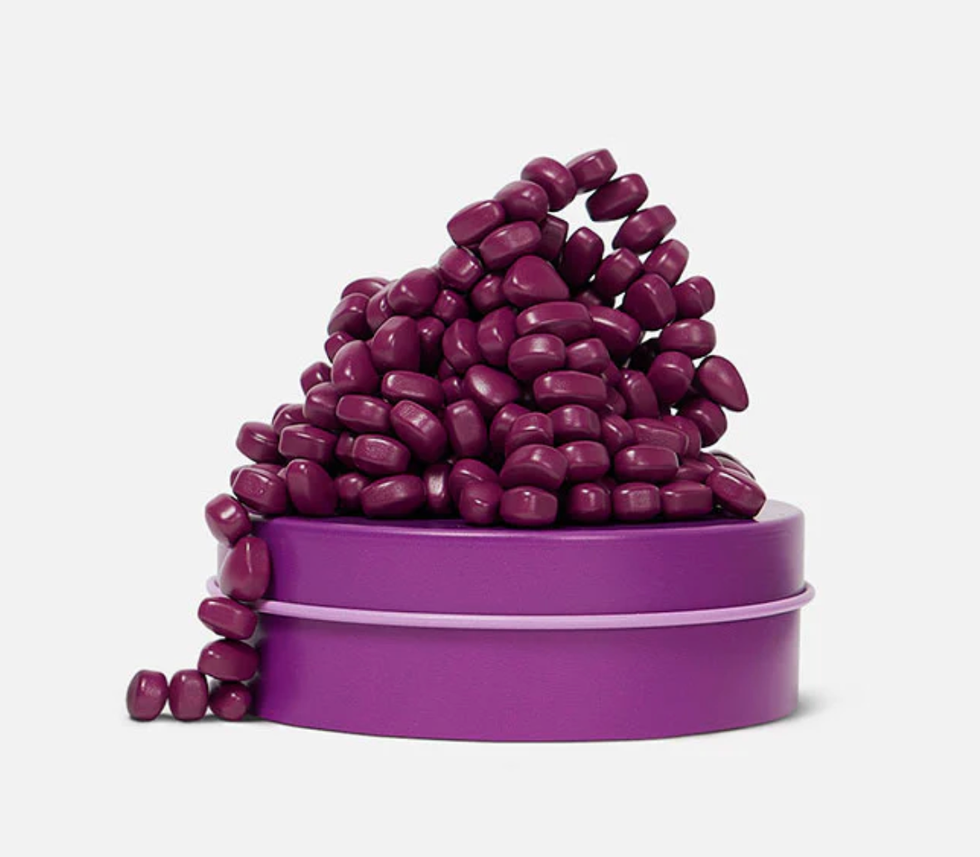 Purple capsules overflowing from a round magenta container.