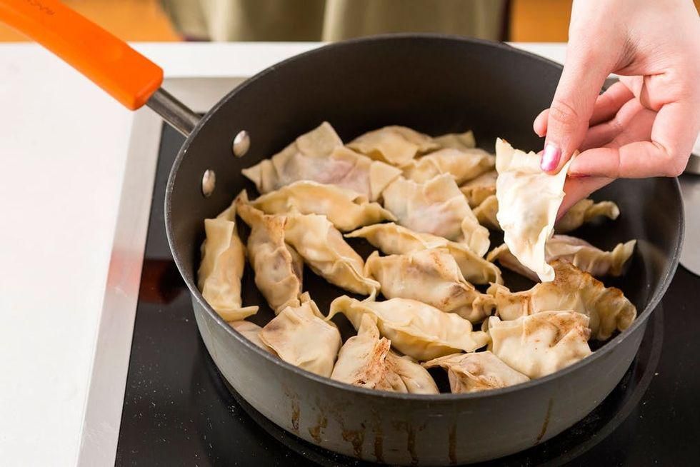 putting vegetable oil into the pan with the potstickers