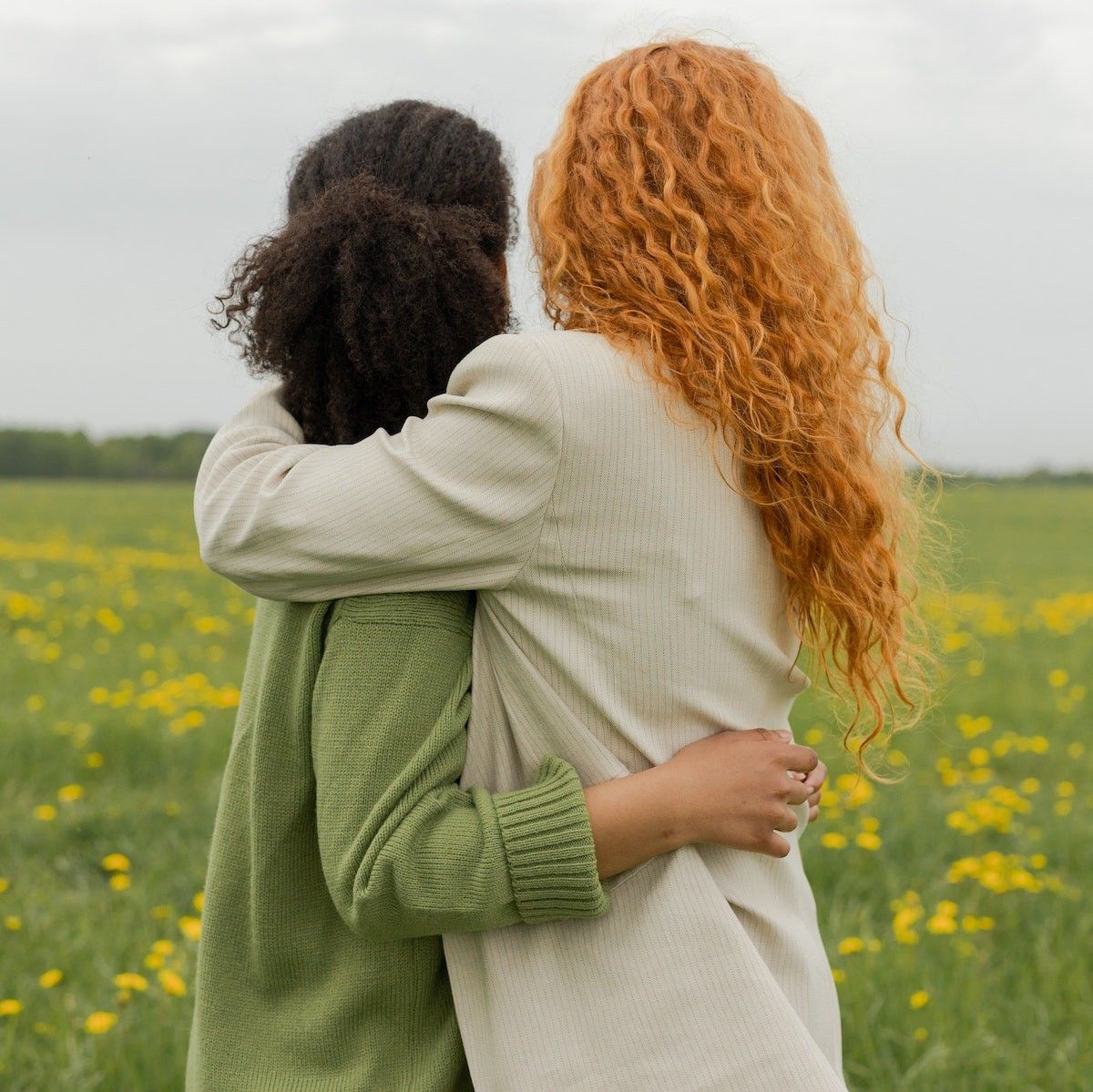 Questions To Ask Your Friends women hugging in a field of flowers