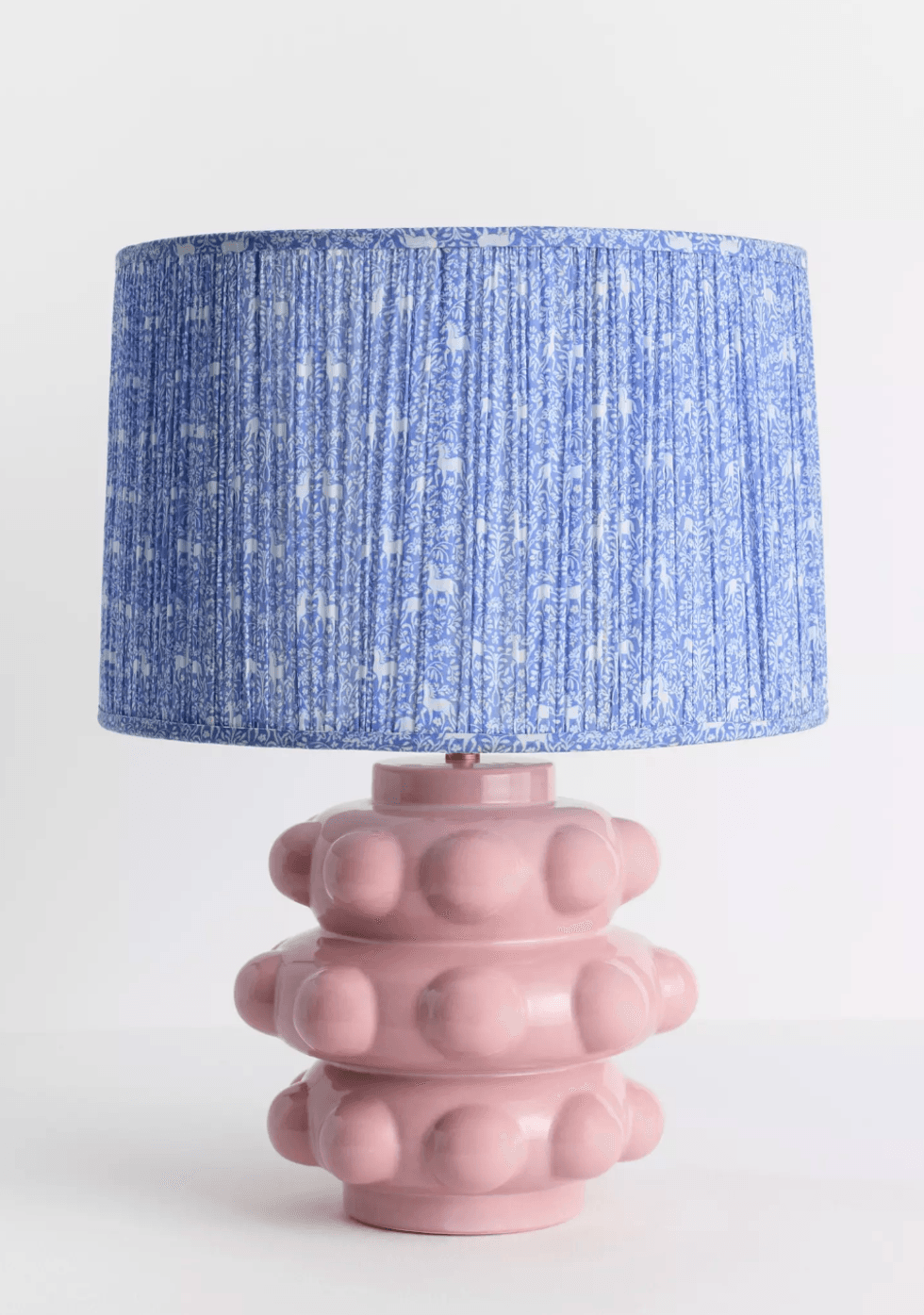 Quirky pink lamp with textured base and blue patterned shade.