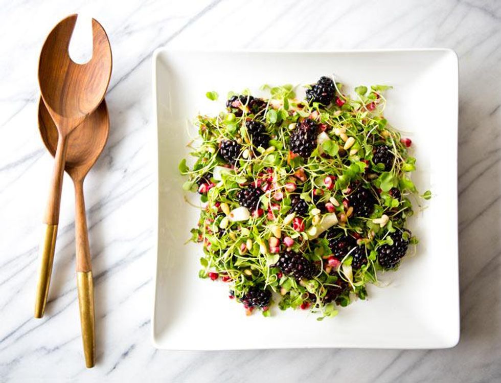 rainbow salad beside wooden utensils