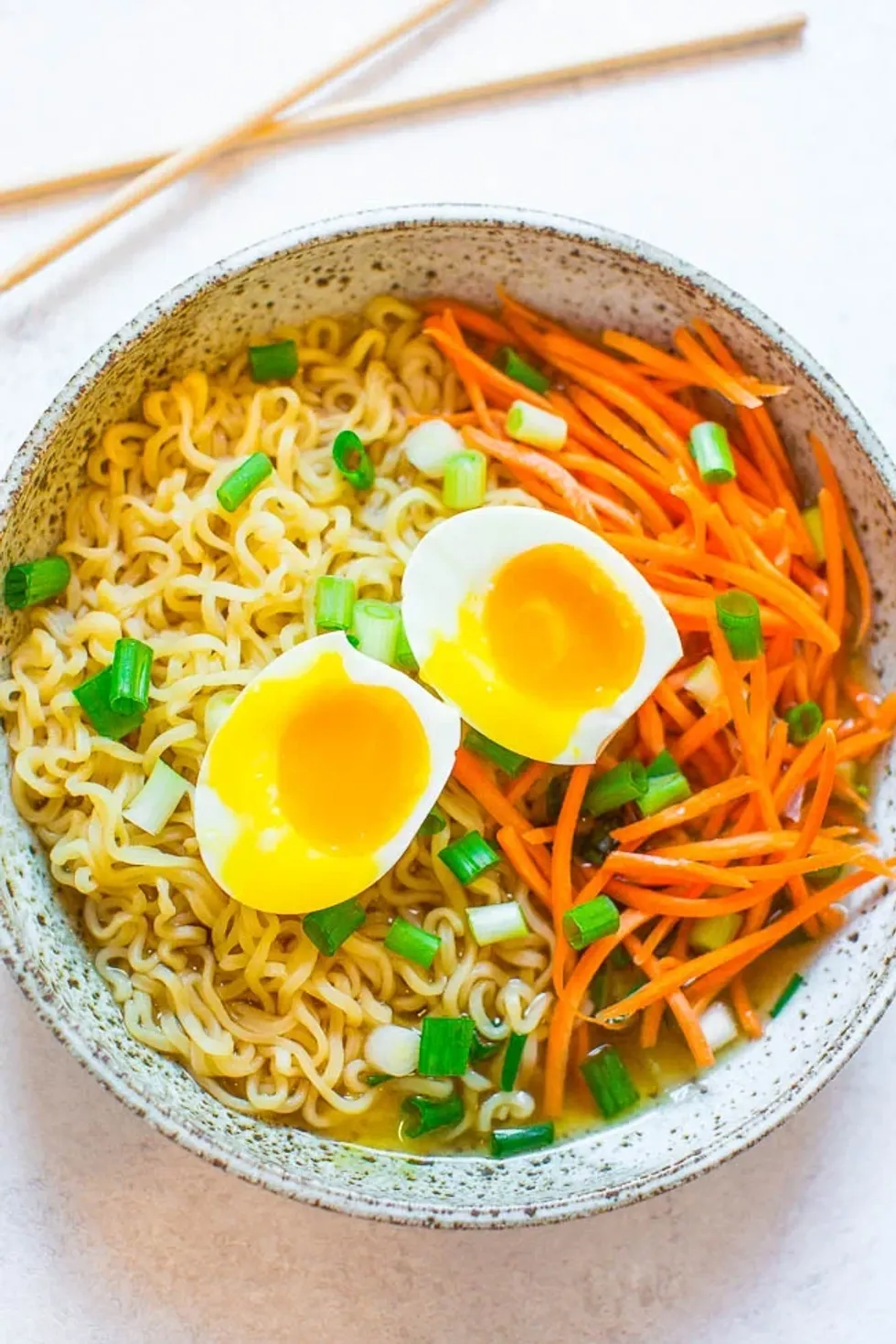 Ramen with egg sits in a speckled bowl.