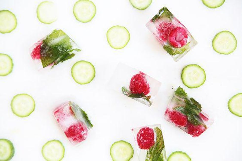 raspberry ice cubes beside slices of cucumber for flavored water