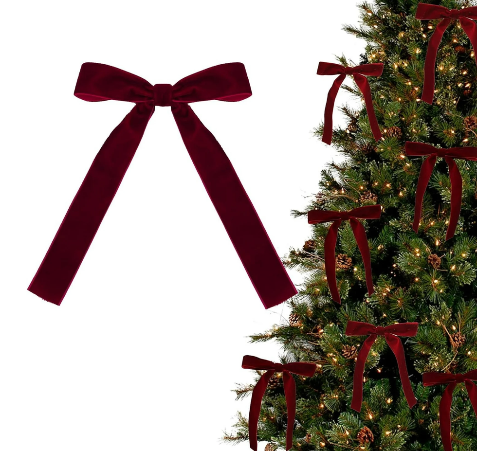 Red velvet bows on a Christmas tree with lights.