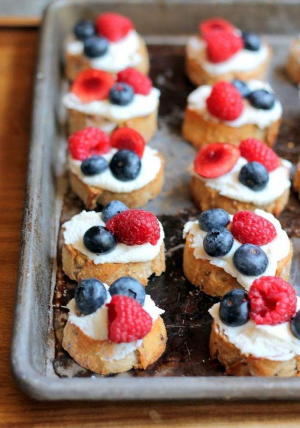 red, white, and blue crostini with ricotta and berries