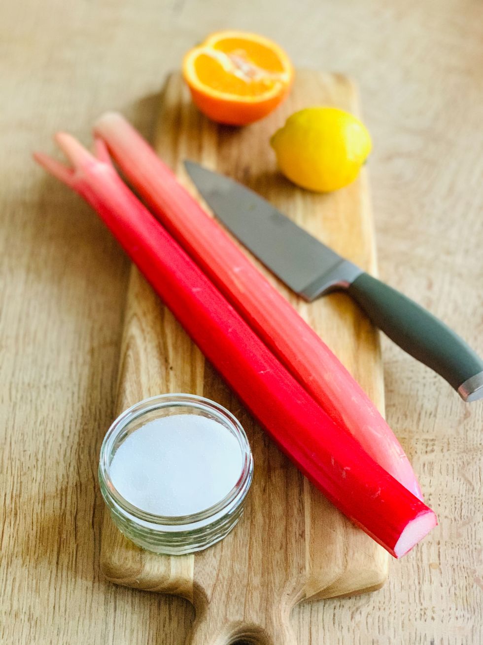 rhubarb stem on a cutting board with white sugar