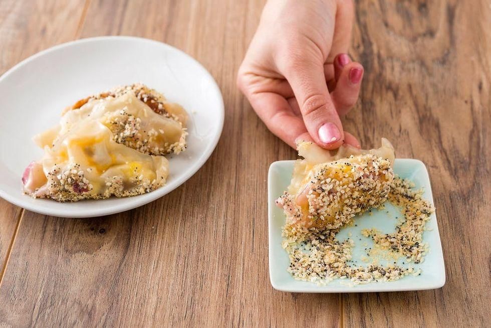 rolling egg and sausage in everything bagel seasoning