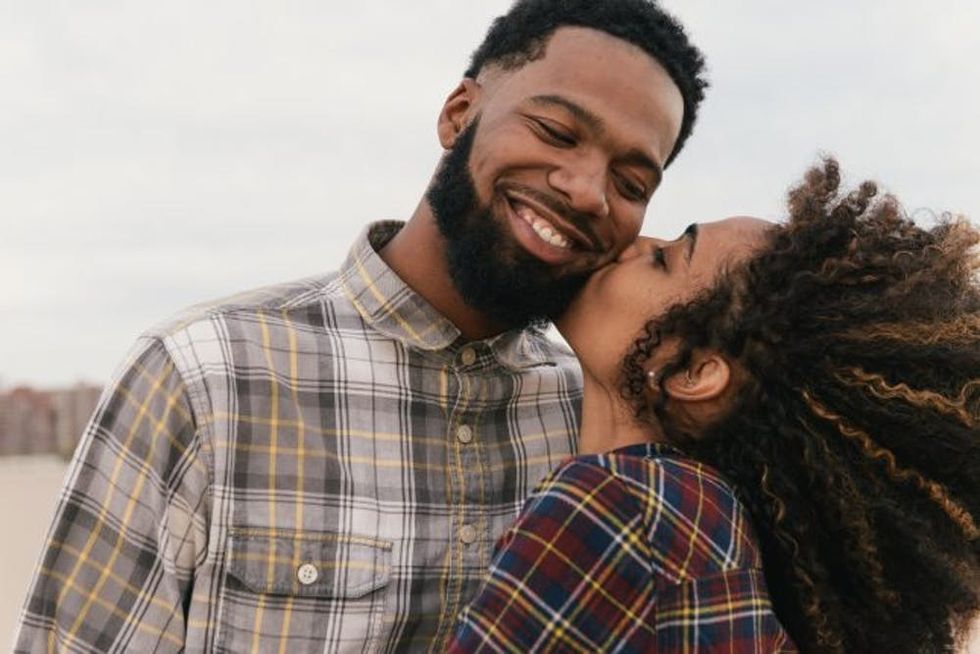 Romantic young couple kissing on beach, Coney Island, New York, USA