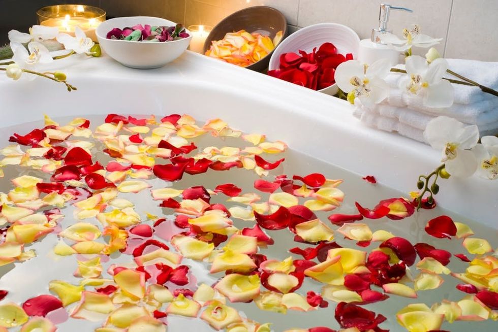 Rose petals float in a bathtub