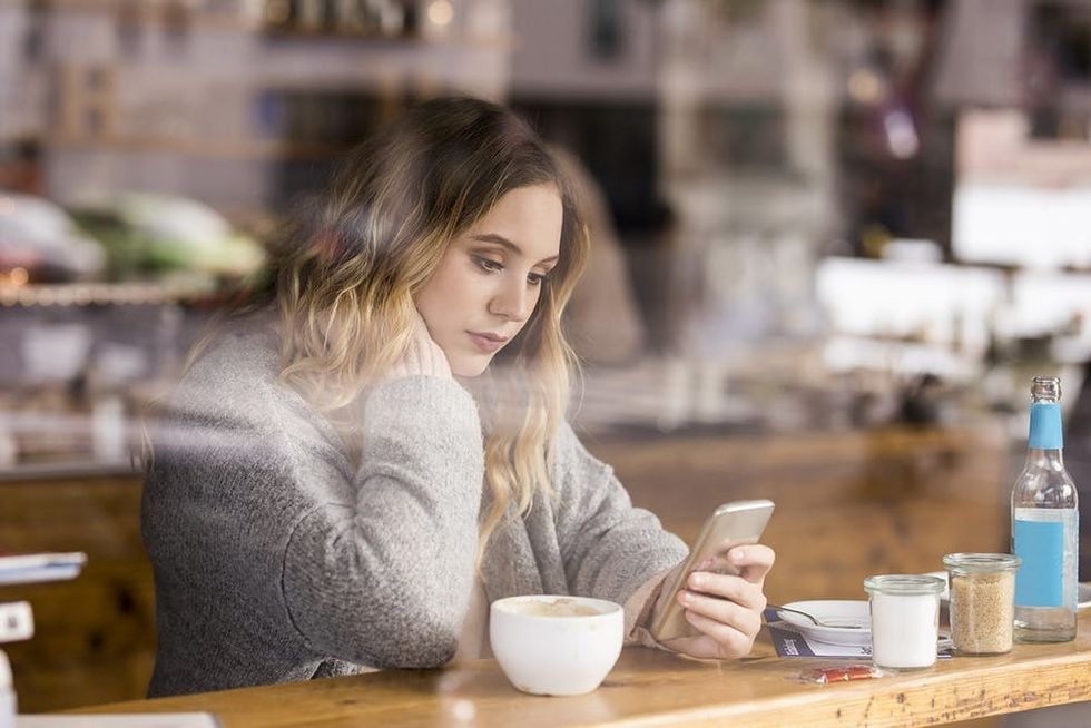 Sad Young Woman looking at cell phone