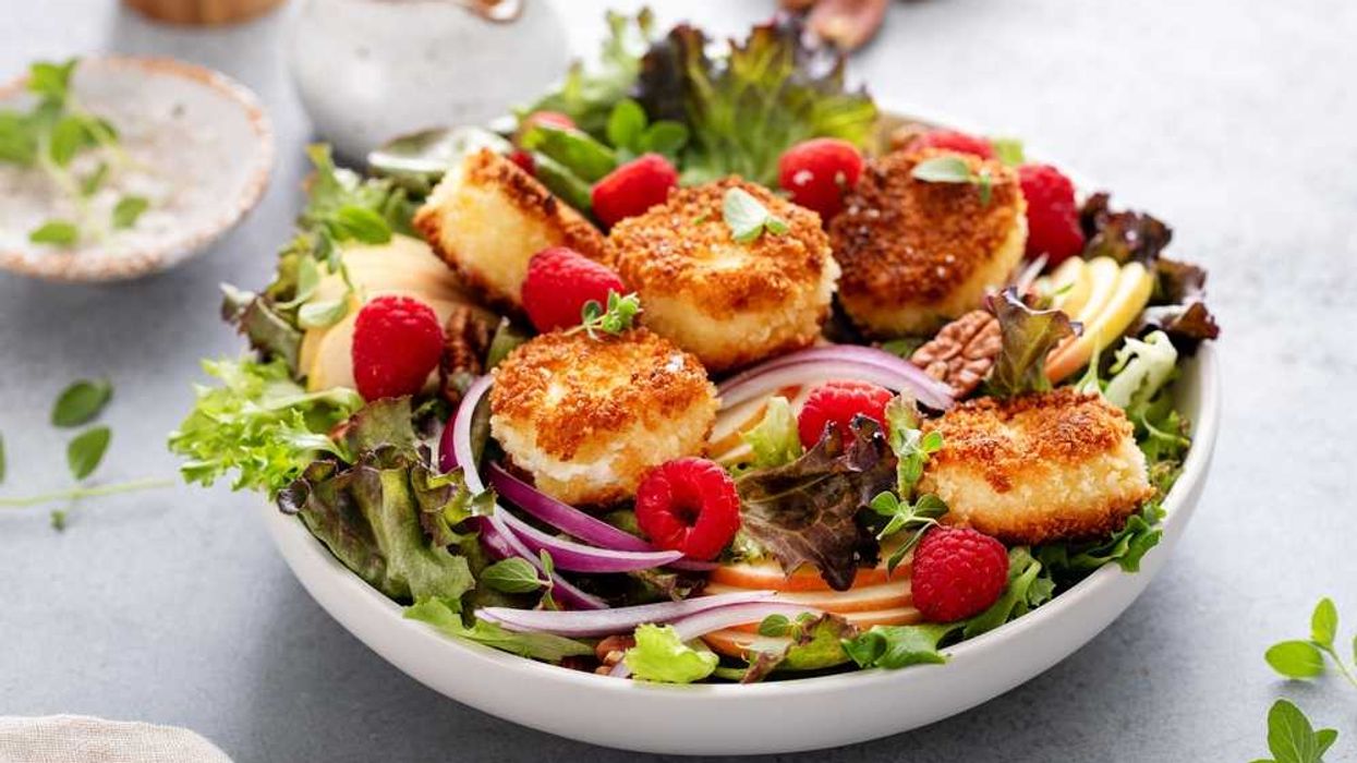 Salad with breaded cheese, raspberries, mixed greens, apple slices, and red onion.