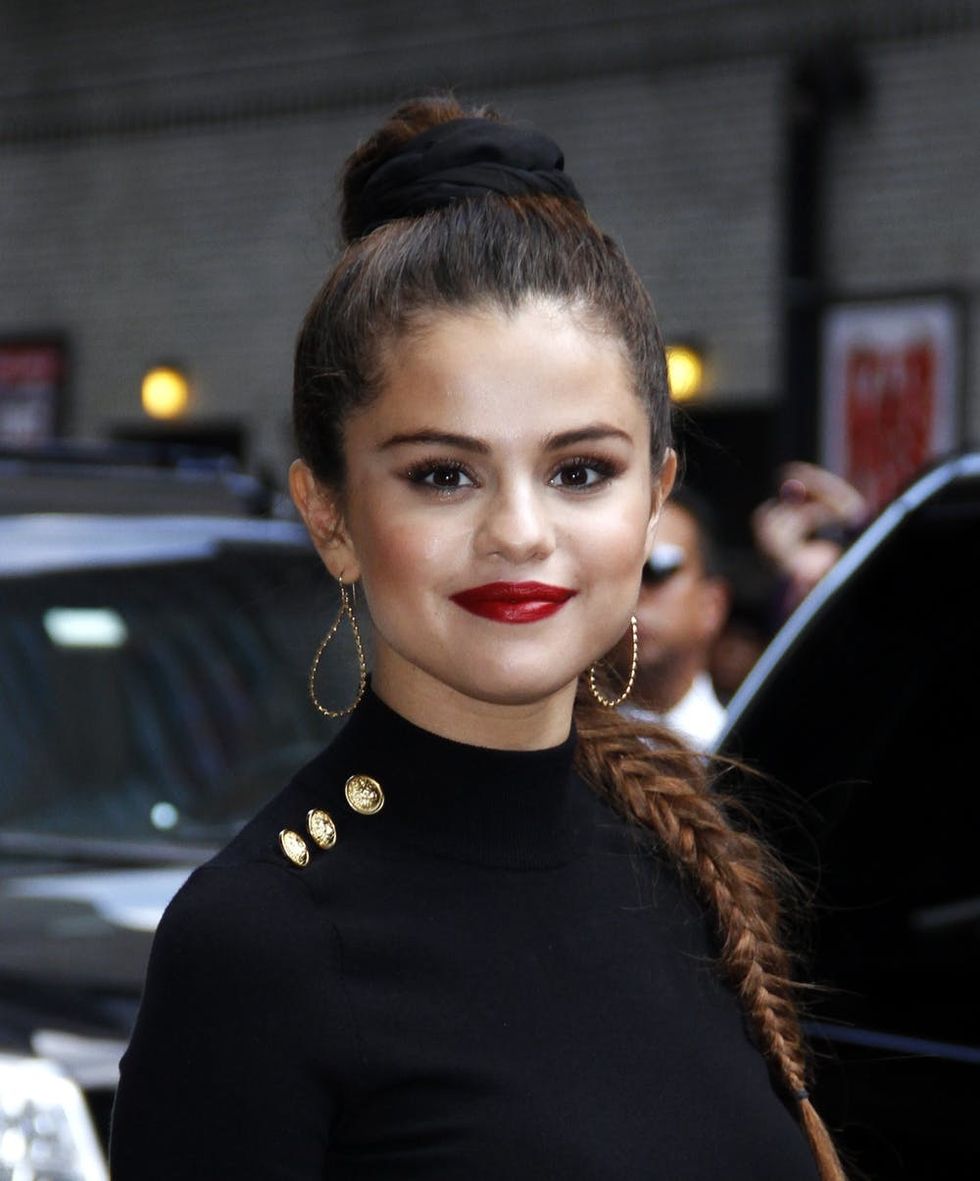 Selena Gomez wearing a high braided ponytail.