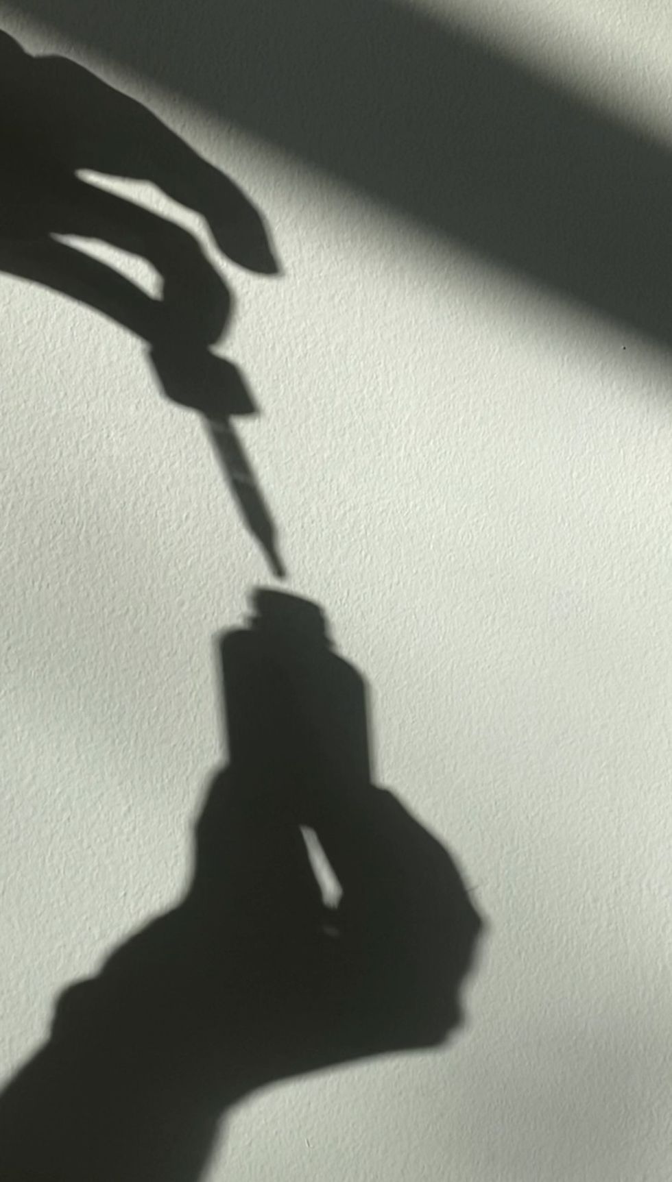 shadow of a skincare serum bottle