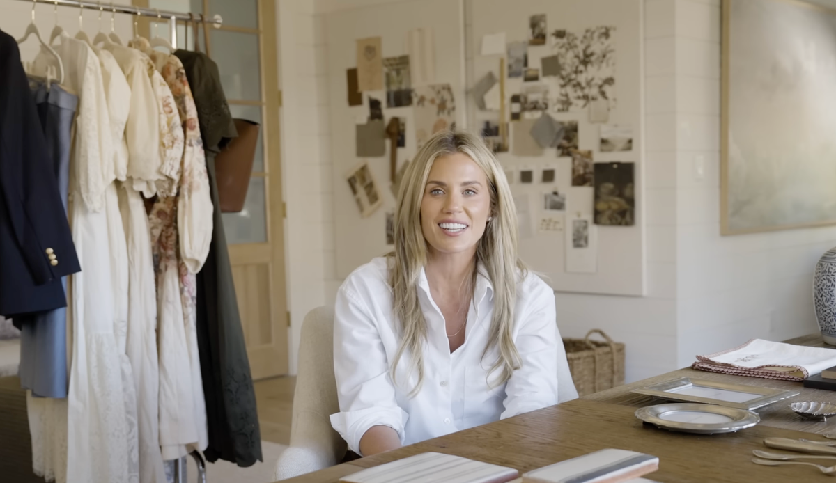 Shea McGee in an office with clothes rack and mood board behind her.