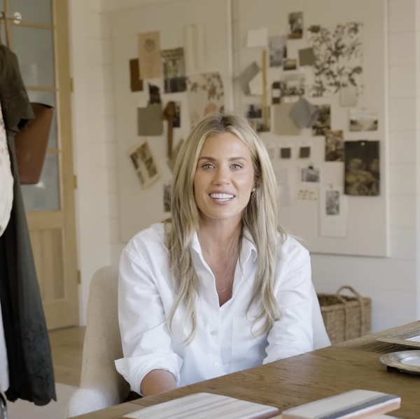 Shea McGee in an office with clothes rack and mood board behind her.