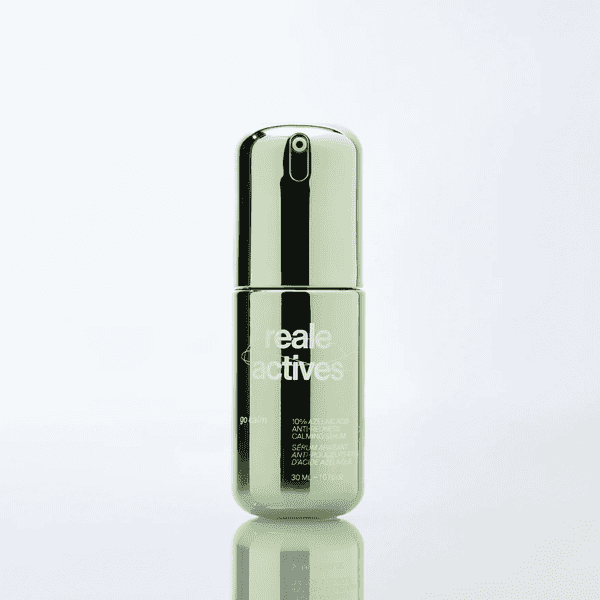 Silver bottle of "Reale Actives" serum with reflective surface on light background.